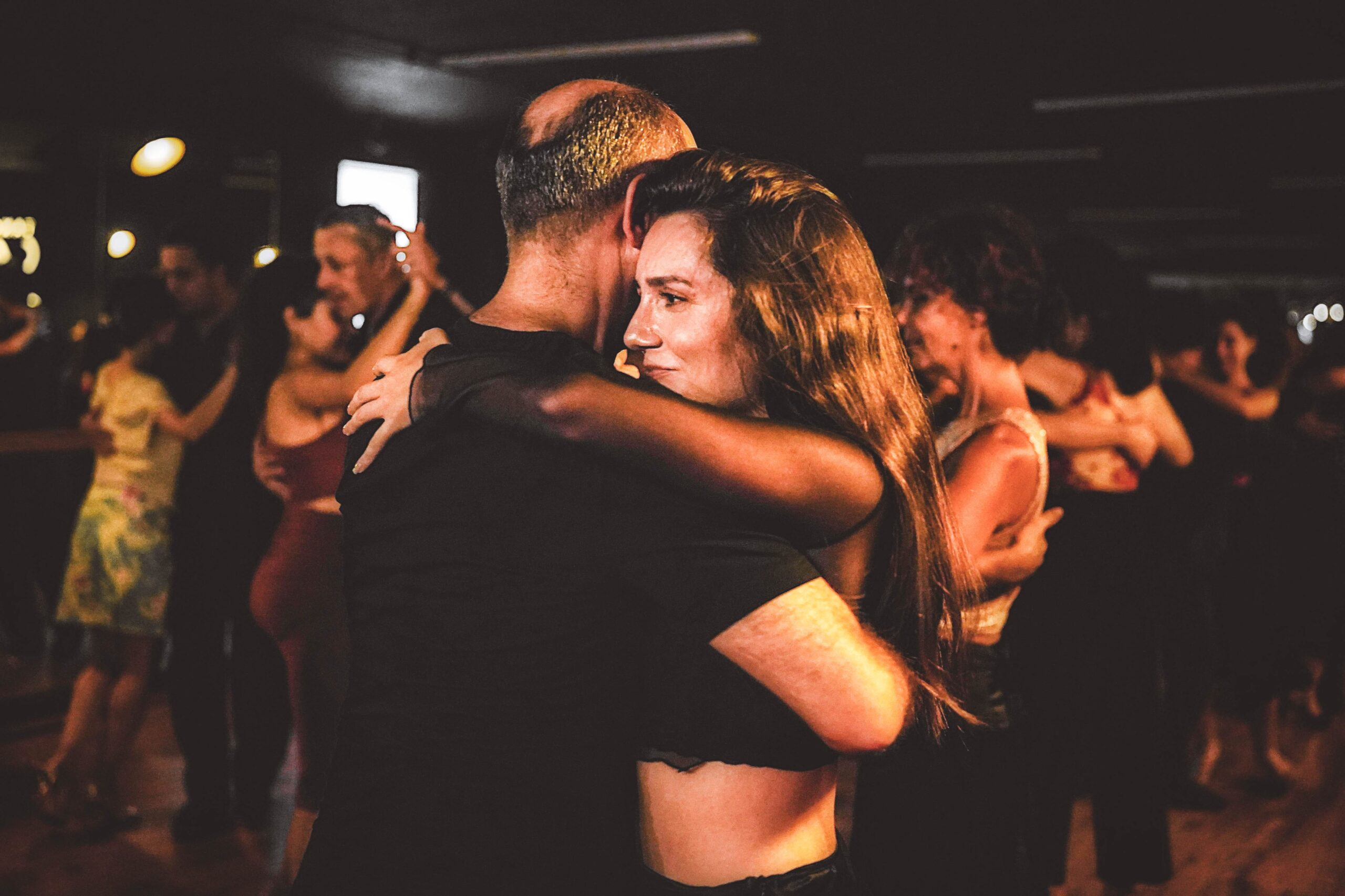 Parejas bailando tango en una clase grupal o milonga